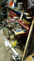 Open red Craftsman drawers with assorted hand tools scattered across top drawer