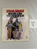 Front cover showing characters wearing transfers and auction tag