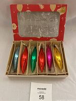 Full view of set of six elongated vintage Christmas bulb ornaments in original cardboard box with red outer packaging.