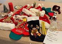 Photo showing Christmas-themed hats, candles, ornaments, and figurines on a table, highlighting variety in the lot.