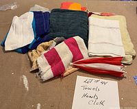 Nine assorted hand towels and cloths spread out on a flat surface with a note indicating 'Towels Hand Cloth'