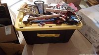 Photo showing one yellow-lidded HDX tough tote partially open with various tools on top, for showing wear and tote style.