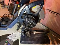 Mastercraft chop saw showing side view with motor and handle visible on a basement floor.