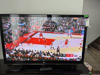 LG Plasma TV 50PT350-UD powered on displaying basketball game with remote in front.