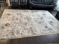 Full view of the Art Deco style rug spread on dark wooden floor with furniture around.