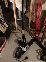 Photo showing the electric pole saw with power cord and attached extender pole.