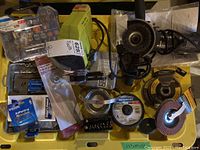 Overview of all tools including Angel Grinder with wire brush, grinding and cutting disks, chain sharpener, and accessory sets in a yellow bin.