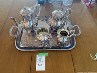 Full set with tray including teapot, coffee pot, sugar bowl, and creamer on a wooden table.