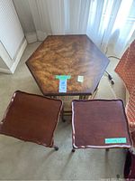 Photo showing three wooden side tables: one hexagonal with wood grain finish and two smaller scalloped edge tables