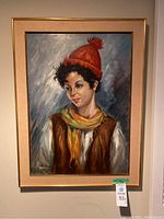Framed oil portrait of a young person with a red knit hat and scarf, signed Giulio Romani, size 24x32 inches.