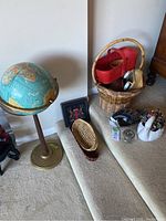 Overall view showing vintage globe on stand and baskets clustered on the right side