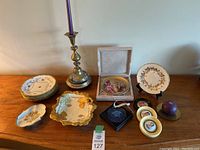 Wide view of entire lot showing porcelain plates, trays, candleholders, framed plate.