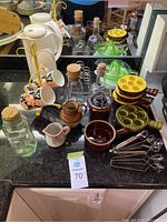 Photo of entire lot showing escargot dishes, tongs, ceramic pitchers and mugs, glass bottles with corks, and citrus juicers