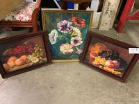 Three framed artworks: two fruit still life prints and one flower oil painting on board. Frames vary in color and show wear.