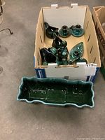 Box of small Blue Mountain Pottery items including salt and pepper shakers, animal figurines, and small pitchers with a large rectangular planter in front