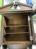 Interior view showing shelves of the wood display case, door open to show storage space inside.