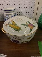Royal Worcester Evesham dish with lid, showing hand-painted fruits and vegetables and a visible chip on the rim.