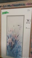 Single framed print showing a hummingbird near flowers with pastel colors, signed by Lena Liu. Frame has a floral pattern and some wear.
