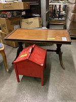 Coffee table and sewing cabinet in storage area with boxes in background. Shows overall look and condition.