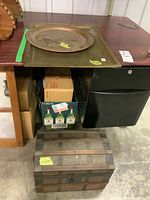 Photo of small wooden steamer trunk on floor showing wood and metal bands with chest shape, visible wear on leather handle missing and hinges needing repair