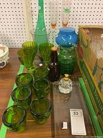 Overall lot showing tray, green goblets, vases, bottle, and candle holders