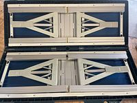 Folded picnic table inside the closed carrying case showing the compact and flat state for transport.