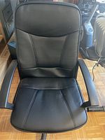 Front view of black office computer chair showing padded seat, backrest, and armrests.