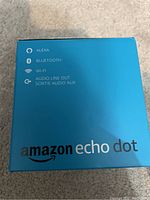 Box of Amazon Echo Dot showing Alexa, Bluetooth, Wi-Fi, audio line out features