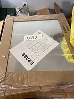 Stacked cardboard-packaged Ikea Krabb wall mirrors, showing furniture manual on top with layout drawing of wavy mirror arrangement.