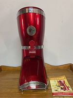 Front view of red Marg-a-Rama margarita maker with chrome trim and included manual.