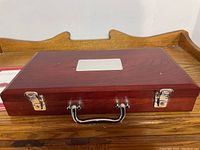 Closed wooden poker chip case with metal clasps and handle