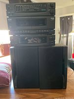 Full view of stereo components stacked and speakers on the side