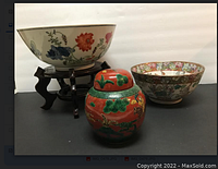 Three ceramic items displayed together: a large Canton bowl on wooden stand, a smaller Canton bowl, and a decorated jar with lid