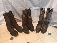 Photo showing the three pairs of cowboy boots placed side by side, highlighting condition differences.