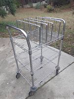 Medical grade wire cart with three shelves and removable dividers on top shelf, outdoor setting