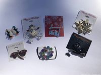 Photo showing seven assorted decorative pins on cardbacks featuring holiday and animal themes