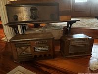 Photo of three antique radios on a table, showing the overall lot and relative size and condition
