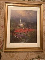 Framed limited edition print titled "Nation's Heritage" by J. Harvey showing a church, flower fields, and people working under a moody sky.