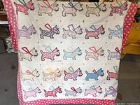Front view of the antique quilt showing the full pattern of applique Scotty dogs and the pink border with white heart motifs.