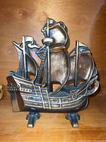 Front view of the bronze or brass ship doorstop showing its detailed masts, sails, and rigging.