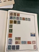 Page from stamp album showing a variety of early French stamps of different colors and subjects affixed within printed borders.
