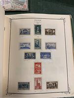 Page inside France stamp book showing older and modern stamps arranged neatly with descriptions on cream colored pages.