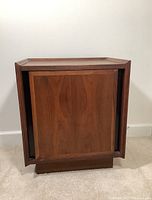 Front view of walnut veneer nightstand, door closed
