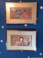 Both framed paintings hung on a blue star-patterned wall