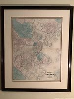 Full view of the framed map showing Boston and vicinity, in a dark wood frame with cream and beige matting.