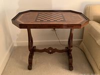 Front view of the wooden occasional table featuring the chess/checker board inlay and base.