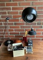 Overall view of vintage desk items including lamps, pencil box, coins in lucite, calculator, and label maker