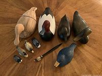 Photo showing all 10 duck decoys and figurines arranged on wood surface, highlighting size and color variations.