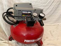 Full side view of the Porter Cable air compressor showing red tank and grey motor with brand label.