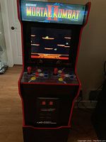 Front view of cabinet powered on showing game screen, marquee and control panel.